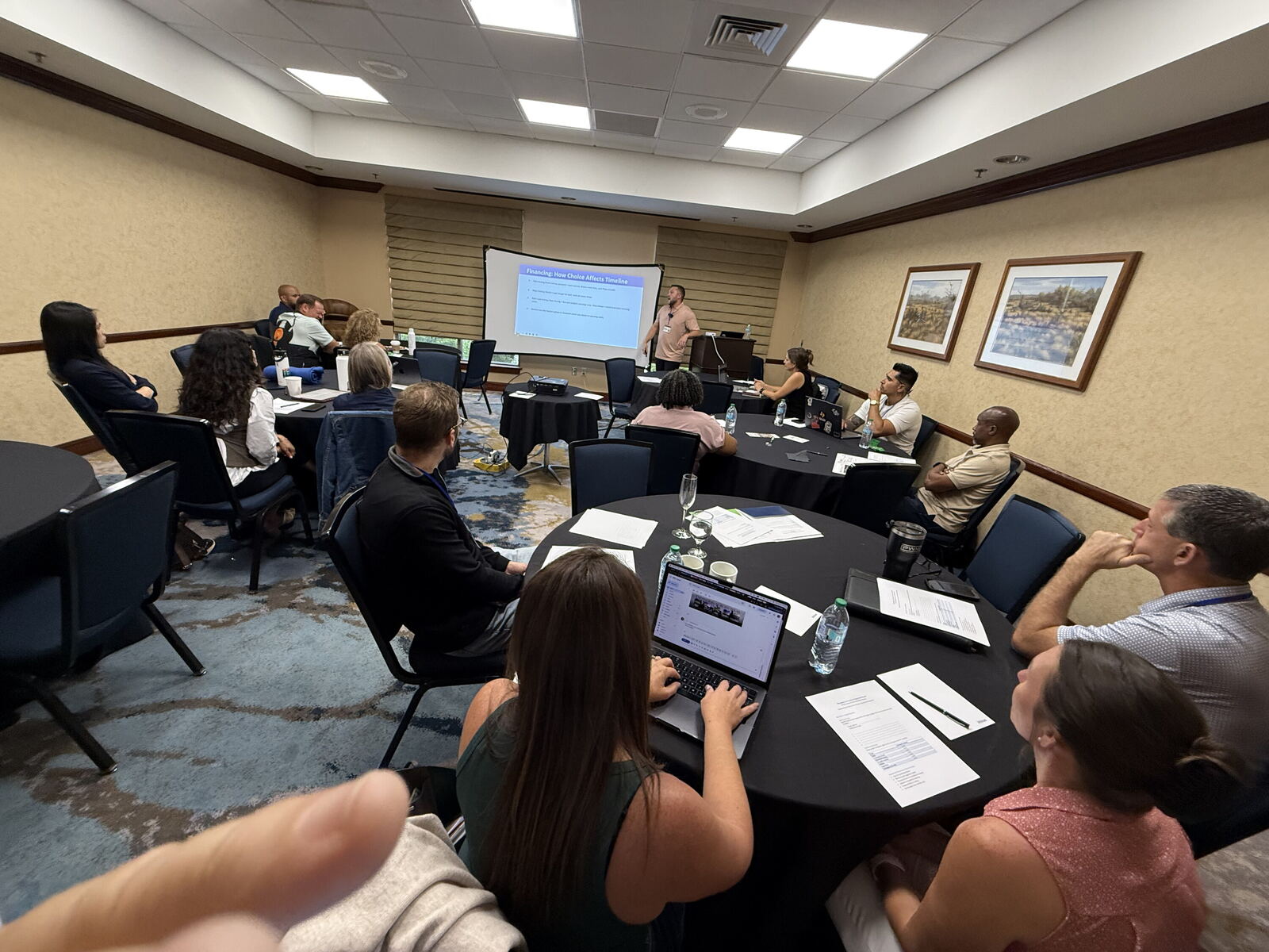 A full classroom, laptops open, building along with the speaker